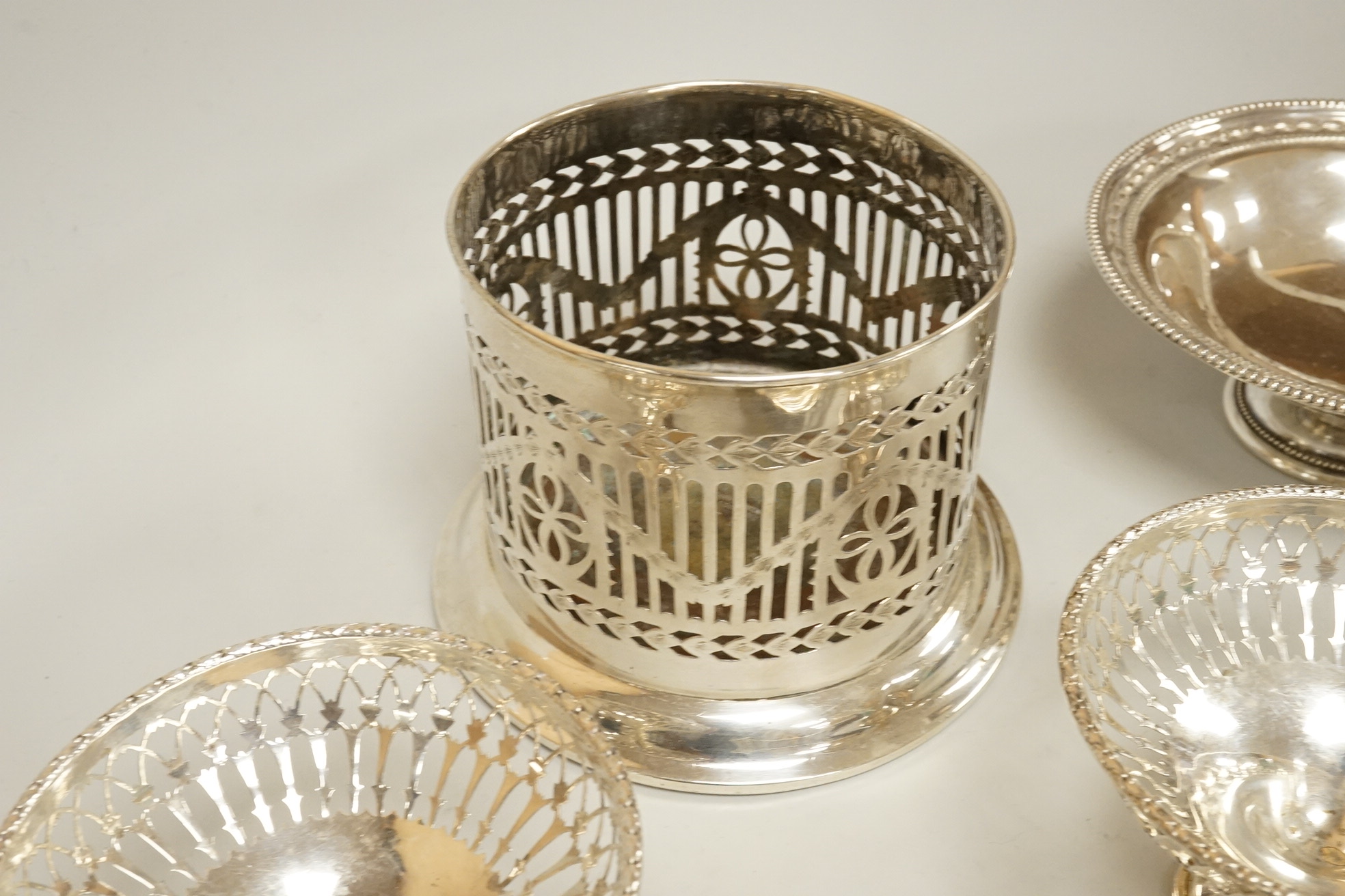Two pairs of early 20th century silver bonbon dishes, including smallest by Mappin & Webb, Birmingham, 1913, height 6cm, together with an Edwardian silver butter shell and a pair of Edwardian silver mounted bottle coaste